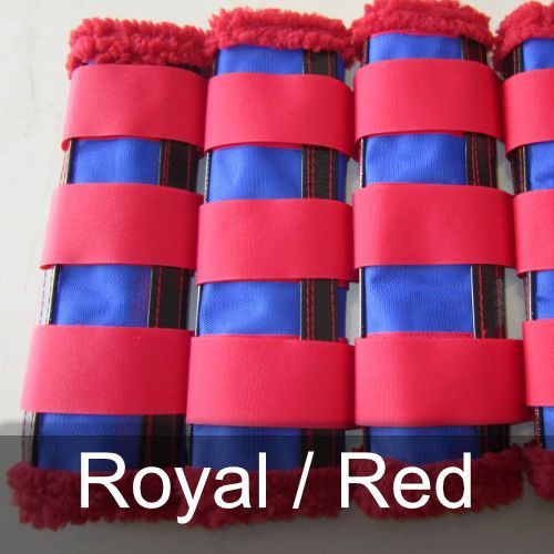 A row of royal / red horse boots are lined up on a table