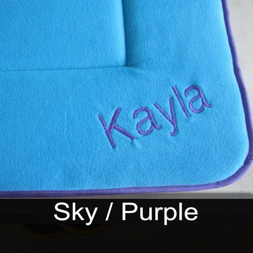 A blue pillow with the name kayla embroidered on it