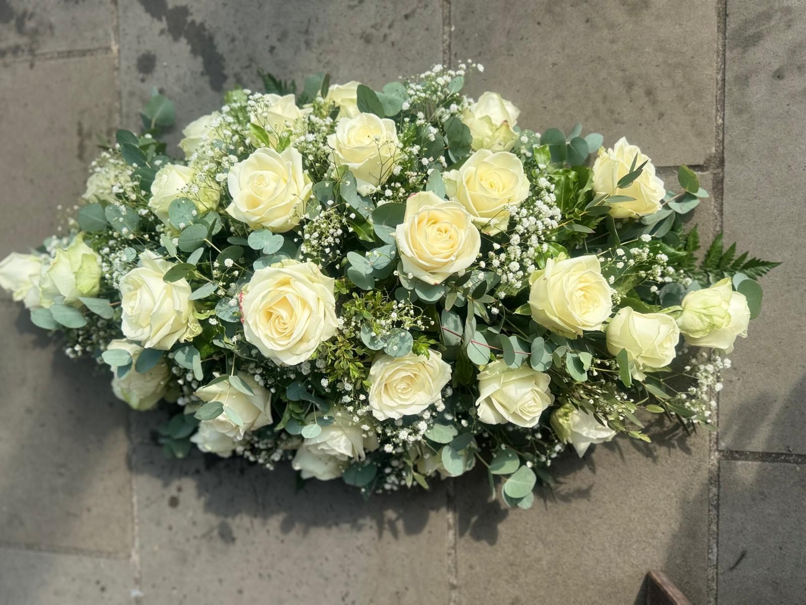 White rose floral arrangement on a gray surface.