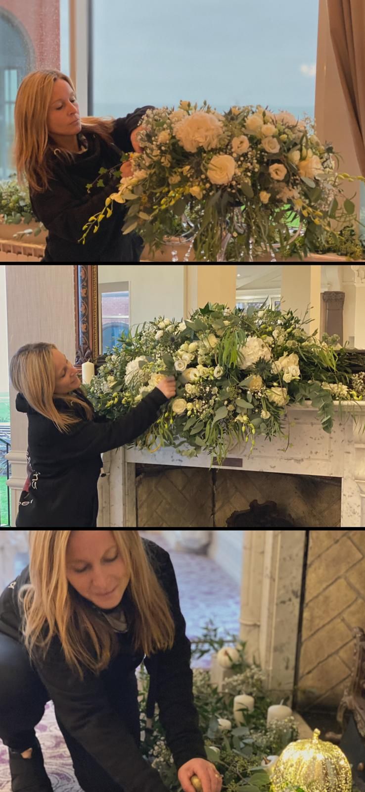 Woman arranging white flowers. She is working on a floral arrangement, possibly for a fireplace or display.