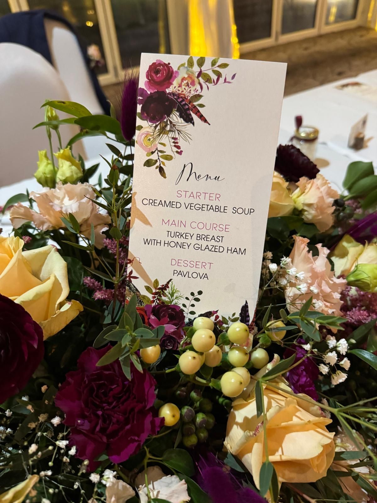 Menu card with floral arrangement: starters, main course, dessert. 