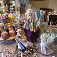 Candy table with pastel cupcakes, lollipops, and treat jars at a decorated party display