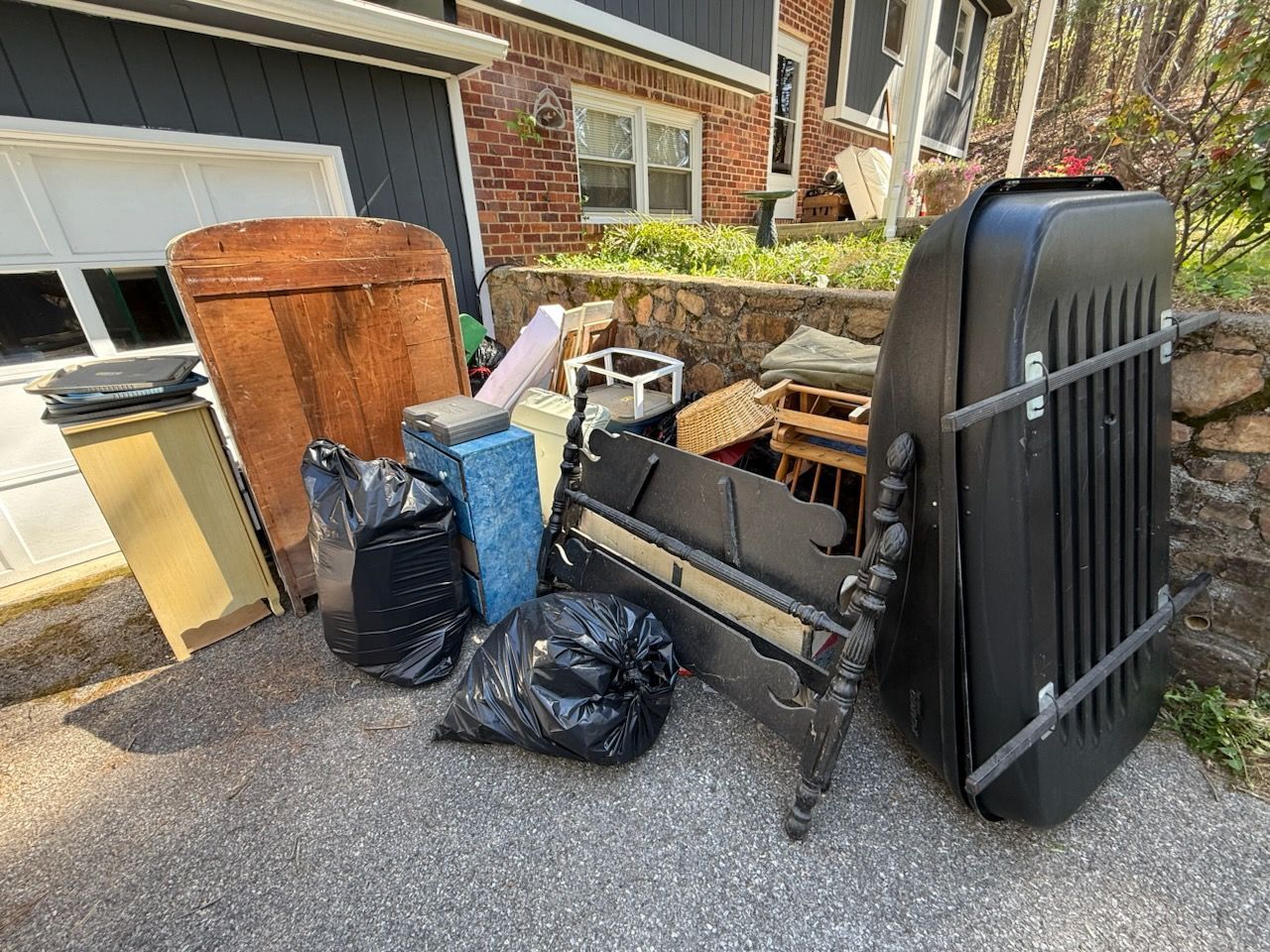 A bunch of trash is sitting on the ground in front of a house.