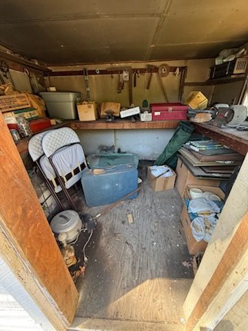 A shed filled with lots of junk and tools.
