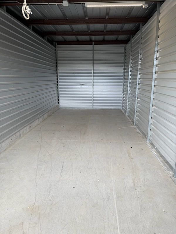 A large empty garage with a rope hanging from the ceiling.