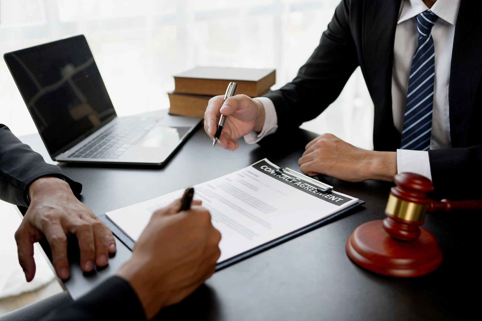 A man is sitting at a desk with his head in his hands.