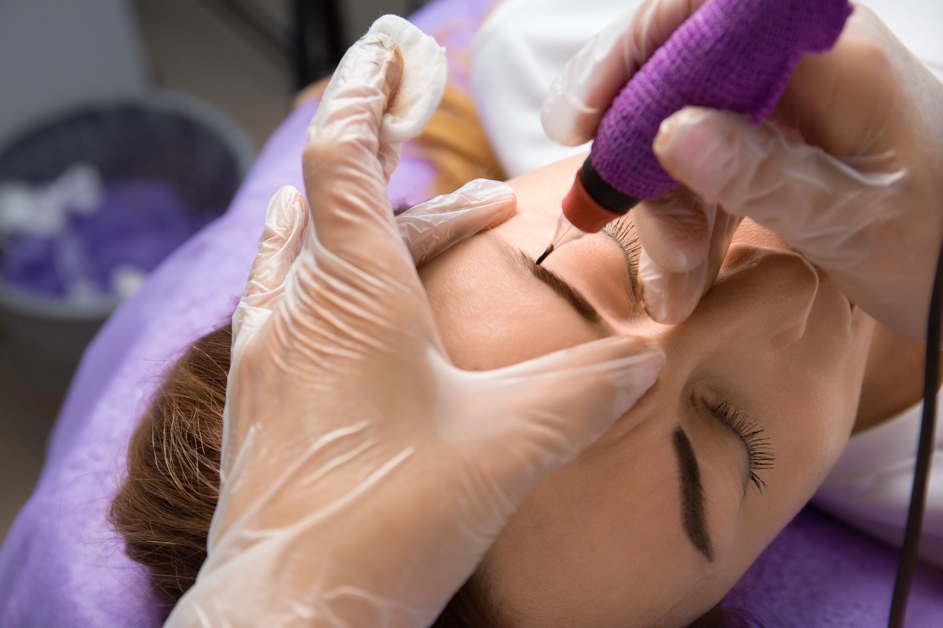 Una mujer se está haciendo un tatuaje de maquillaje permanente en las cejas.