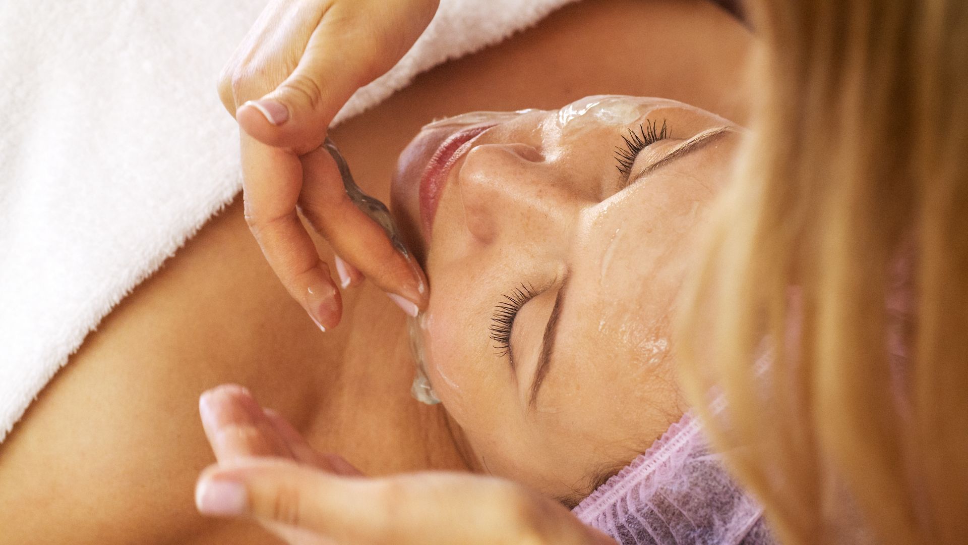 Una mujer está recibiendo un tratamiento facial en un spa.
