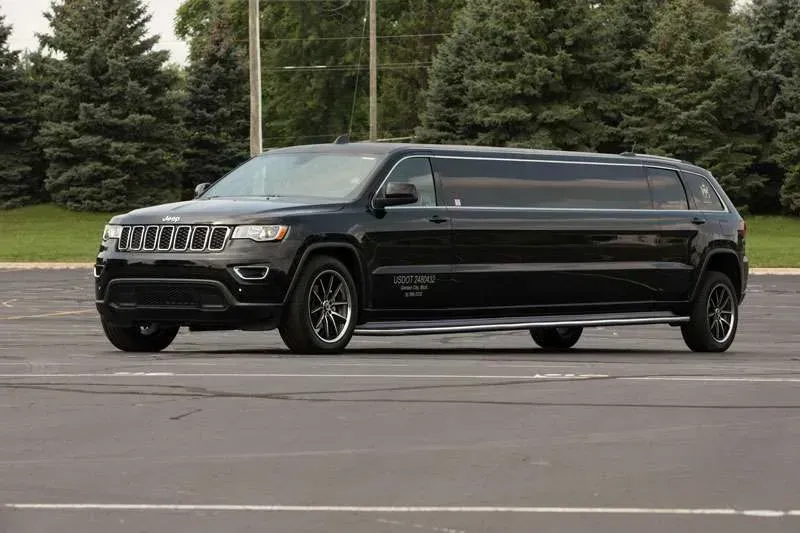 A black chevrolet suburban suv is driving down a road.