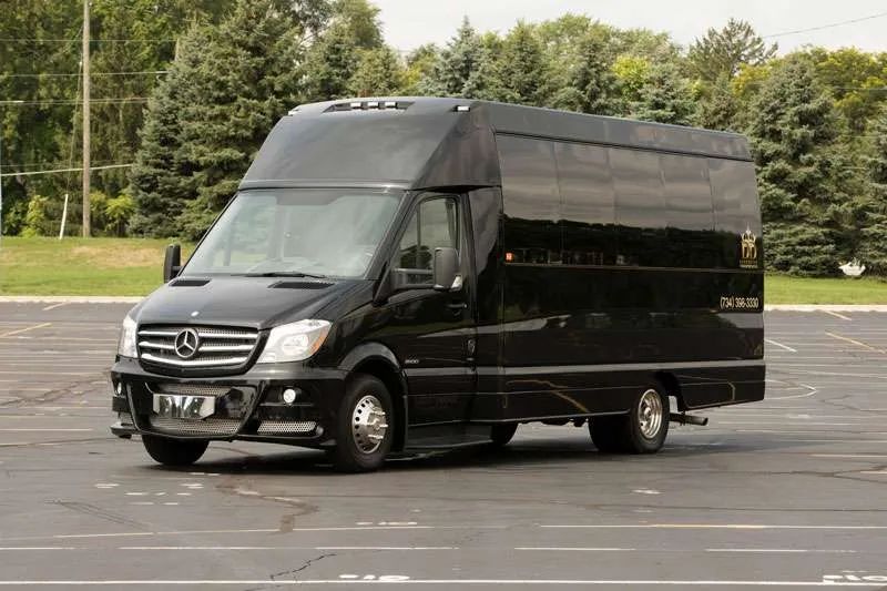 A black mercedes sprinter van is parked in a parking lot.