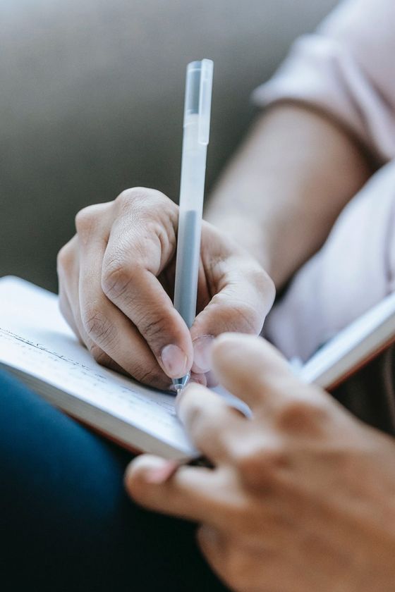 hands writing in a notebook