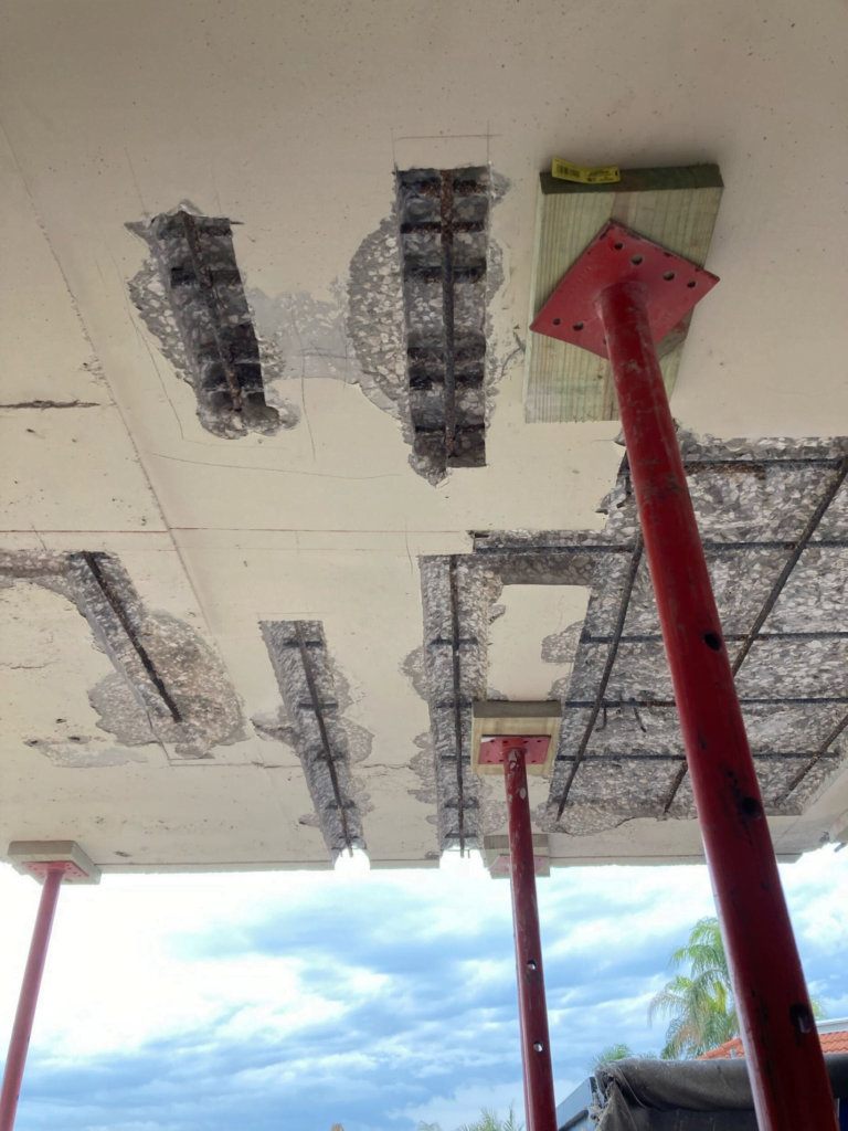 A ceiling with a lot of holes in it and a red pole in the middle.