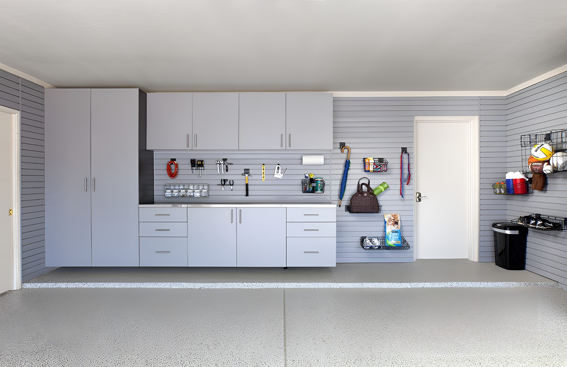 Garage interior with gray cabinets, storage, and accessories on the walls.