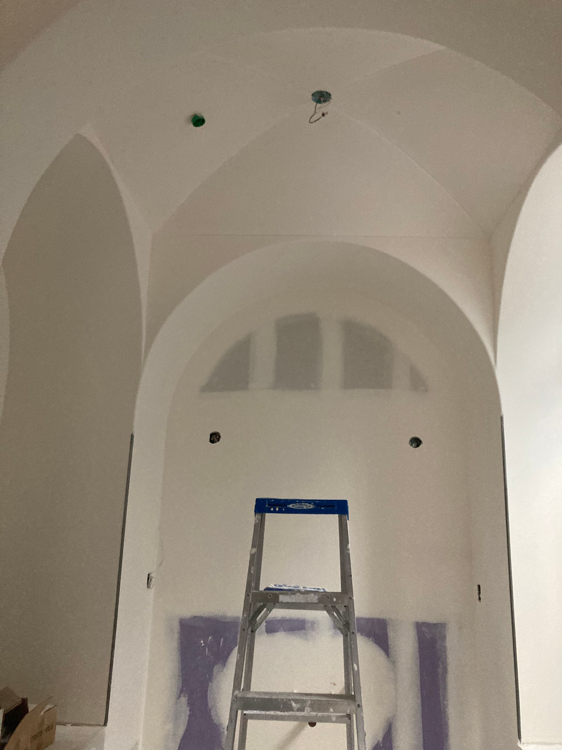 A ladder is sitting in front of a white wall