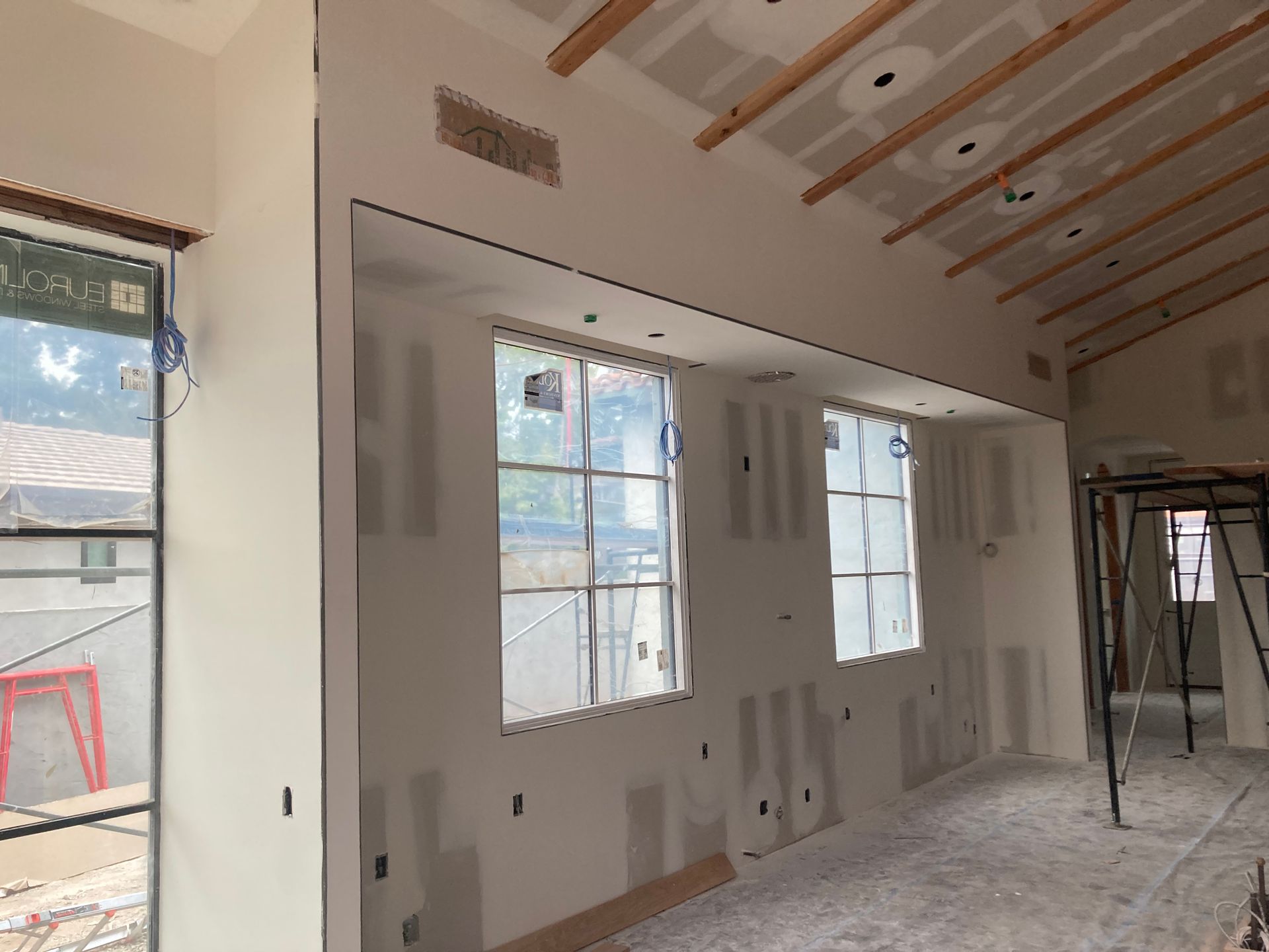 A room with a lot of windows and drywall on the walls