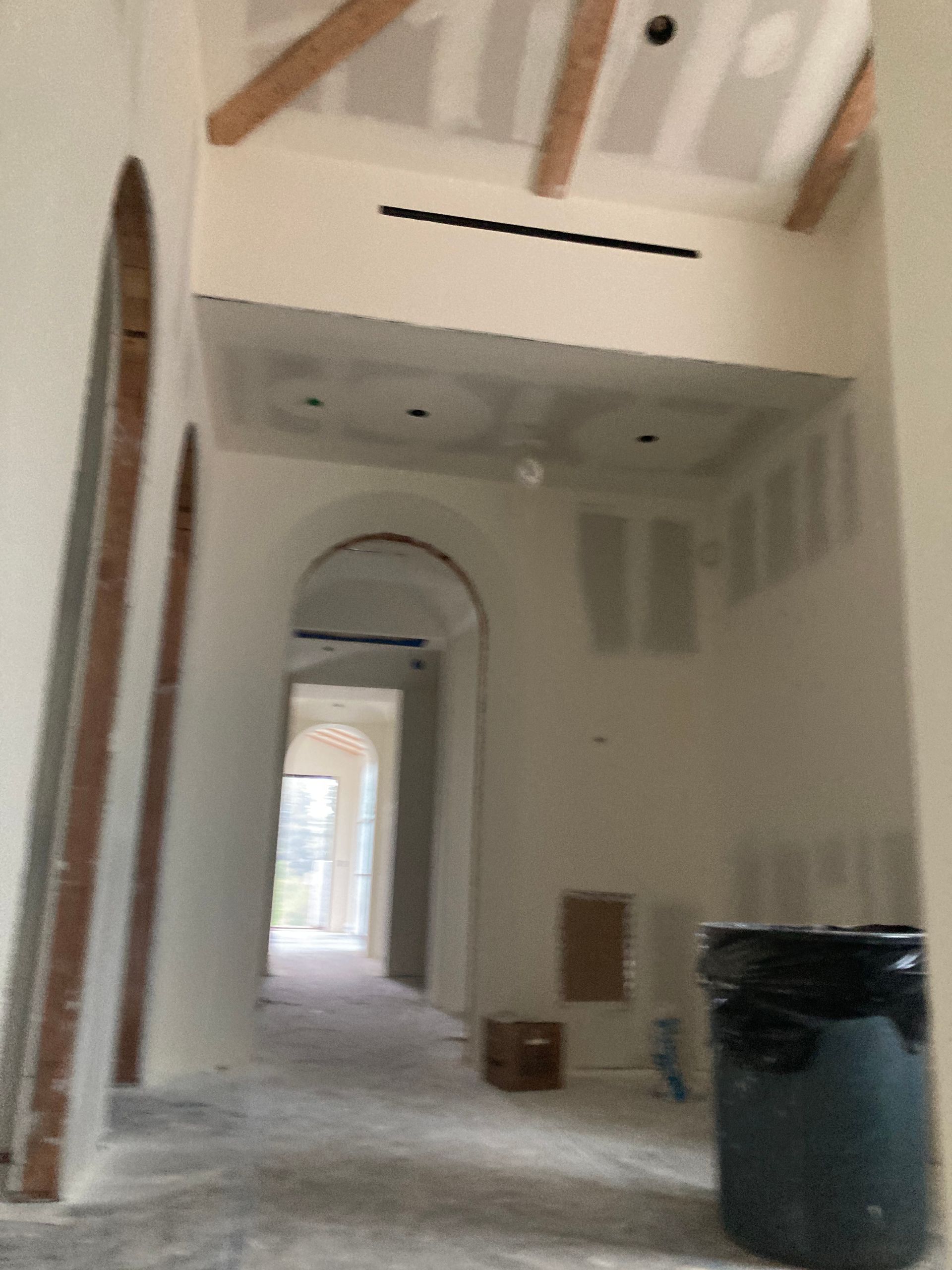 A hallway with a trash can in the middle of it