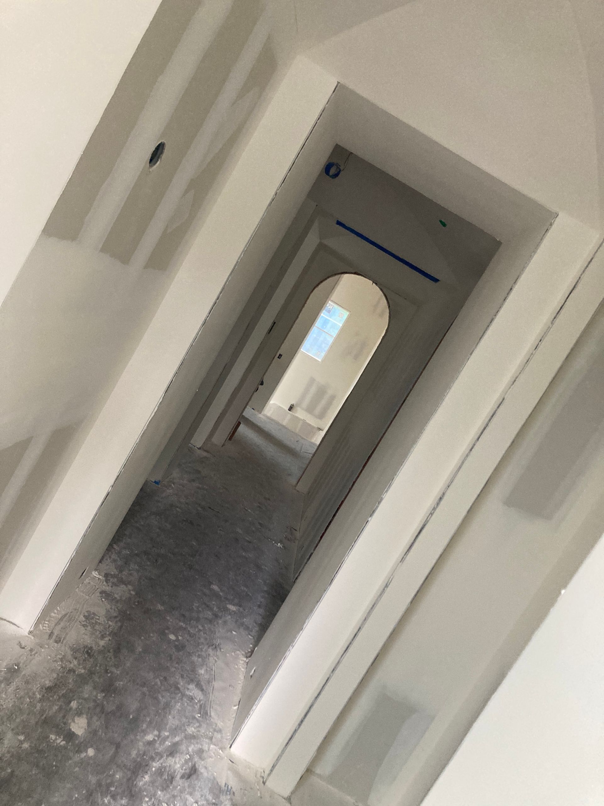 A hallway with a door and a window in the middle of it