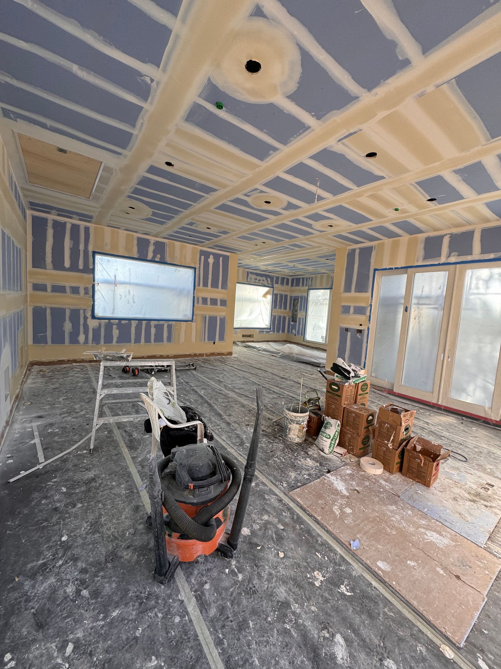 A vacuum cleaner is sitting in the middle of a room under construction.