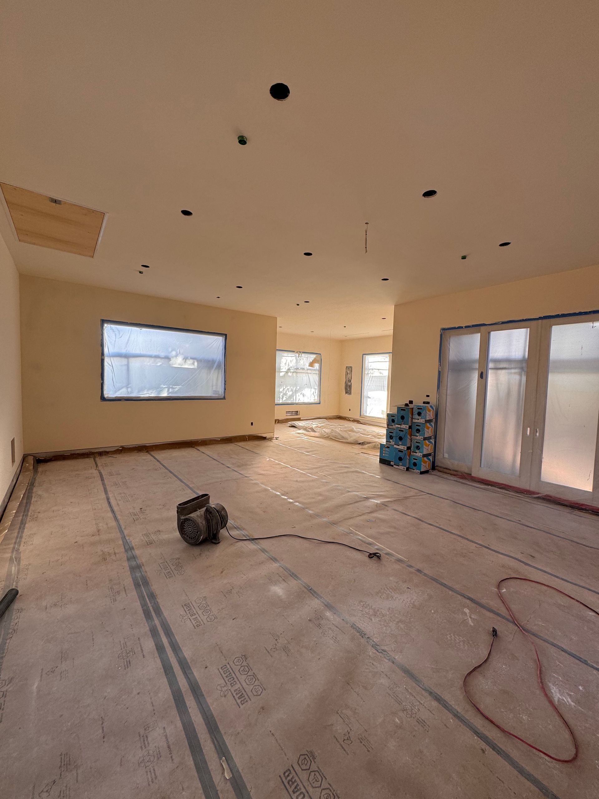 A large room with a lot of windows is being remodeled