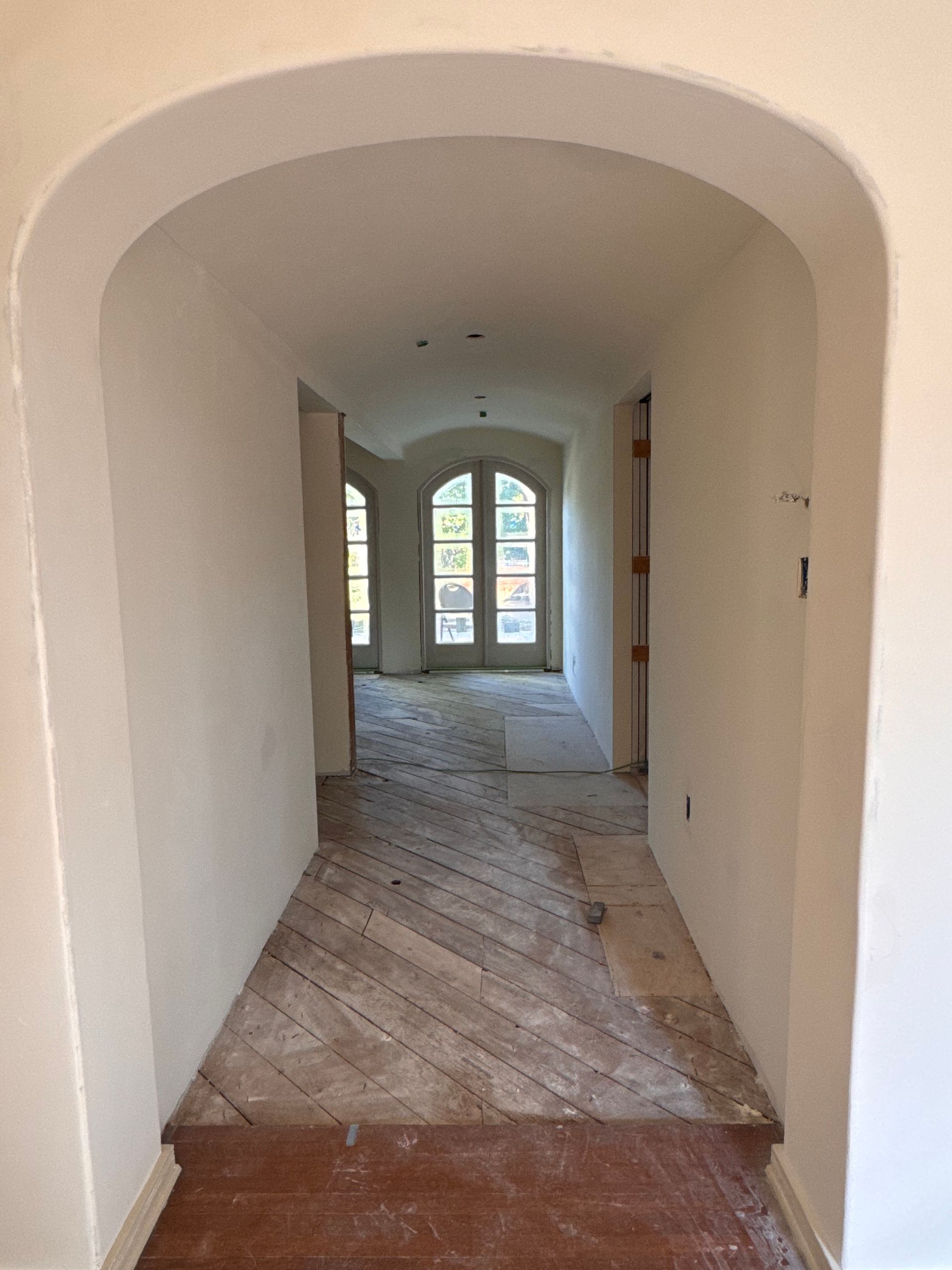 A hallway with arches and a brick floor