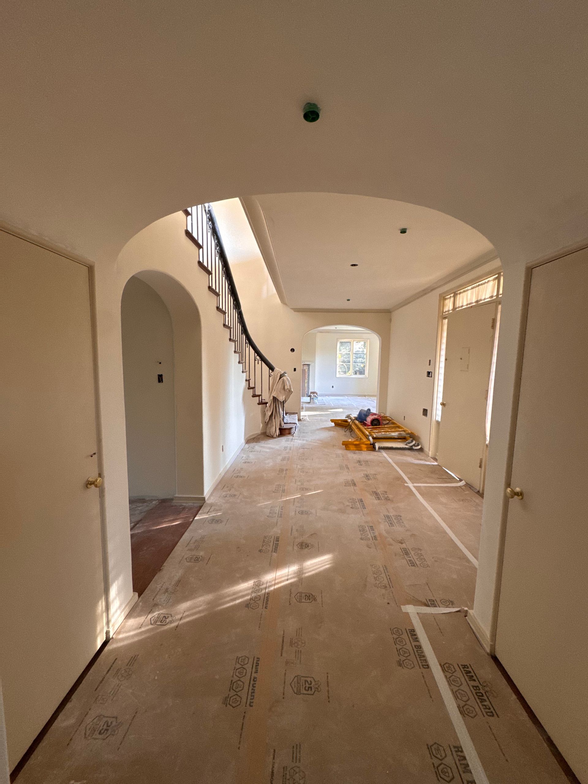 A hallway with a staircase in the middle of it