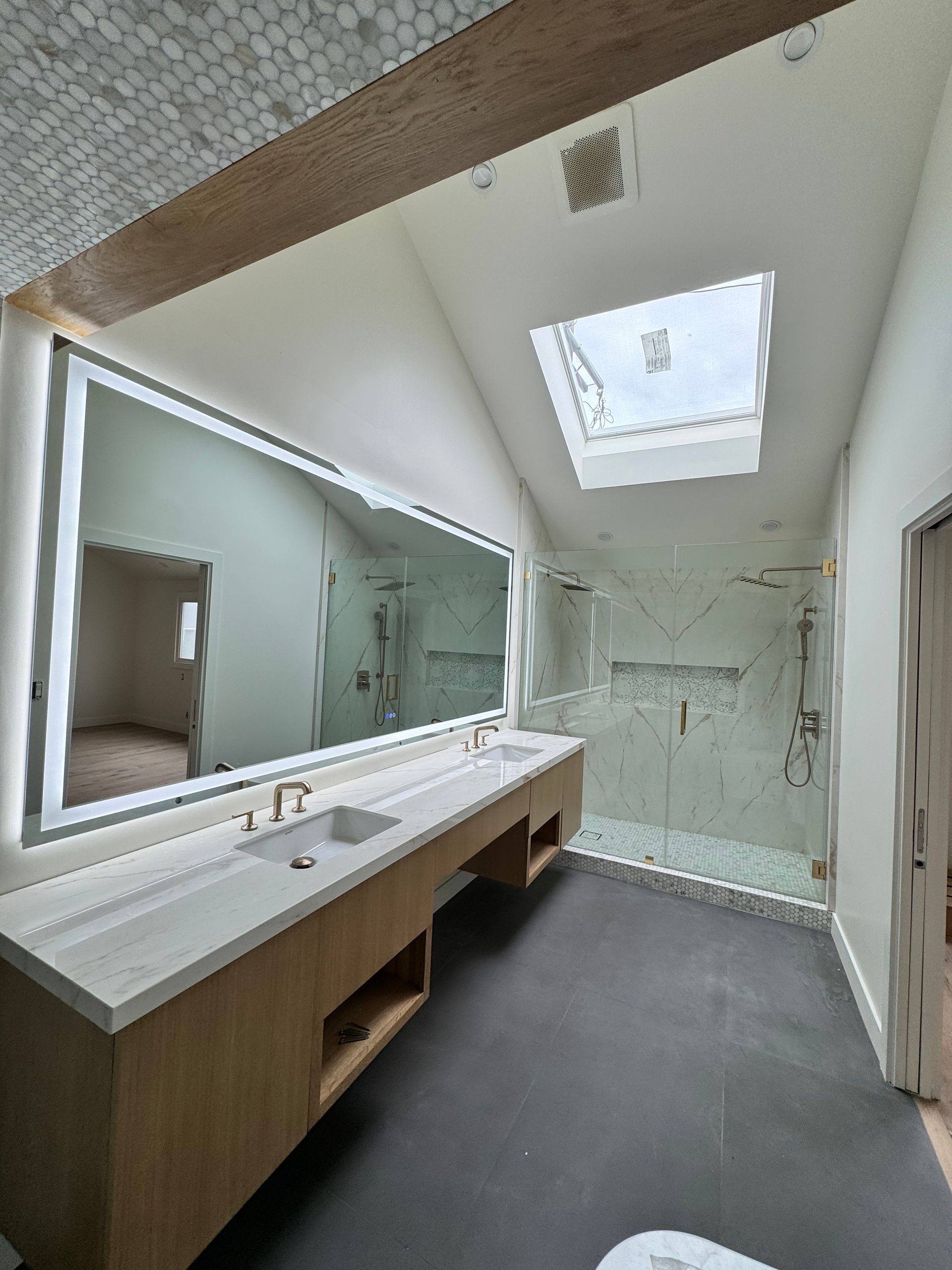 A bathroom with a large mirror and a skylight