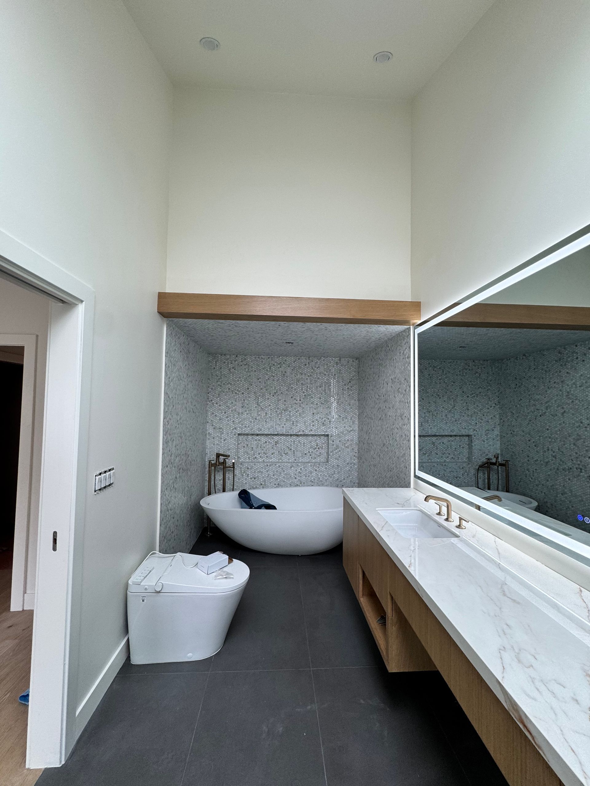 A bathroom with a bathtub , sink , and mirror.