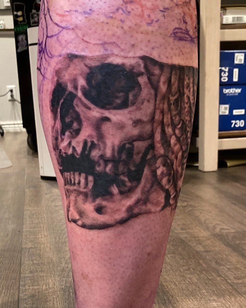 A person has a tattoo of a skull on their leg