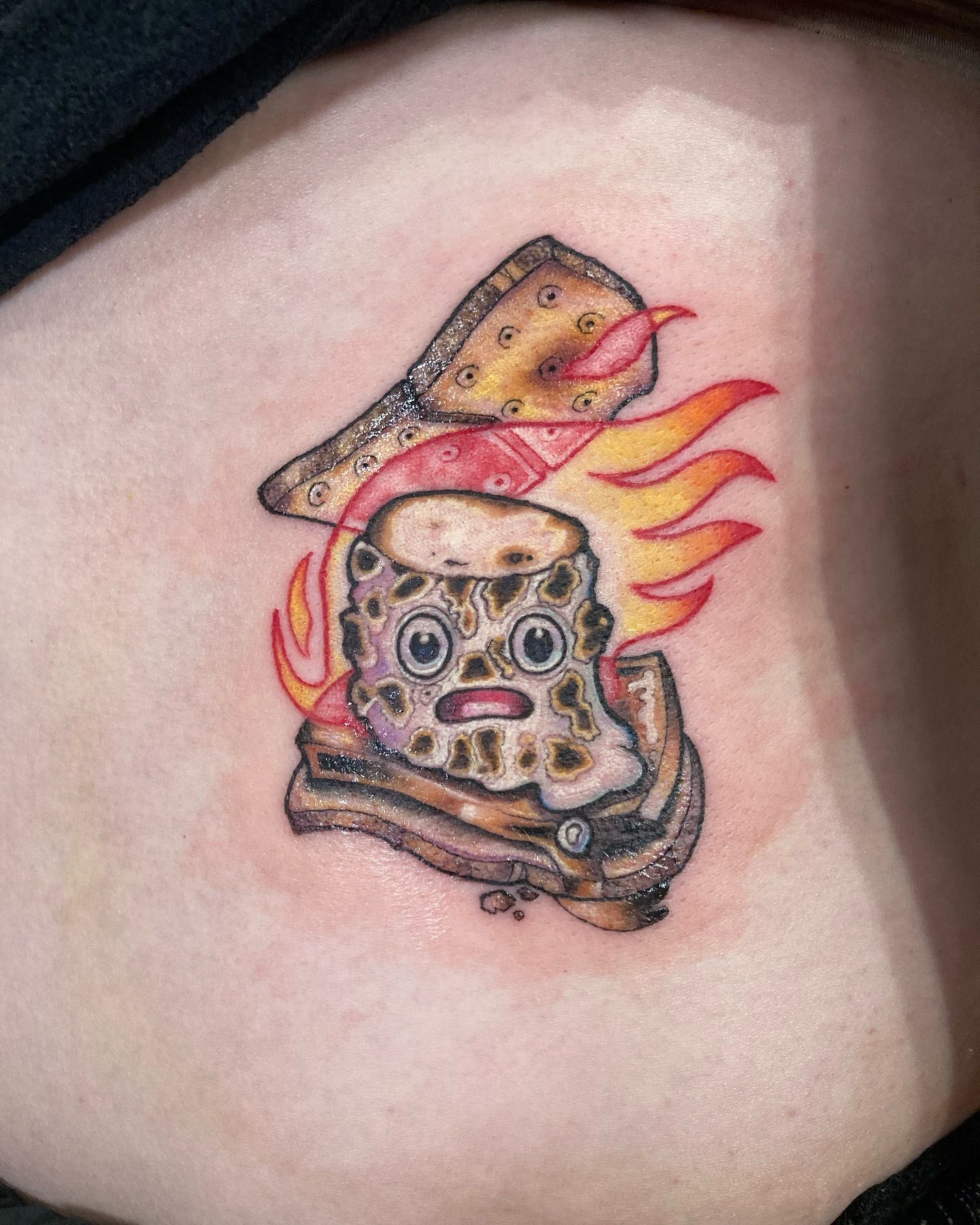 A person has a tattoo of a sandwich on their side.