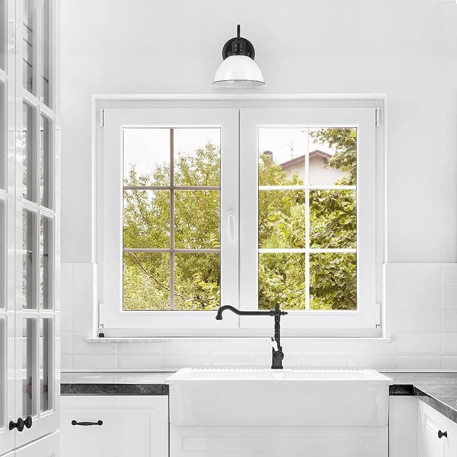 A kitchen with a sink and a window with a view of trees.