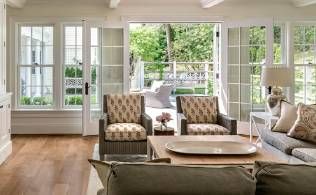A living room with a couch , chairs , coffee table and sliding glass doors.