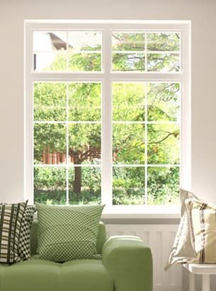 A living room with a green couch and a large window.