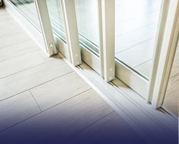 A close up of a sliding glass door on a wooden floor.