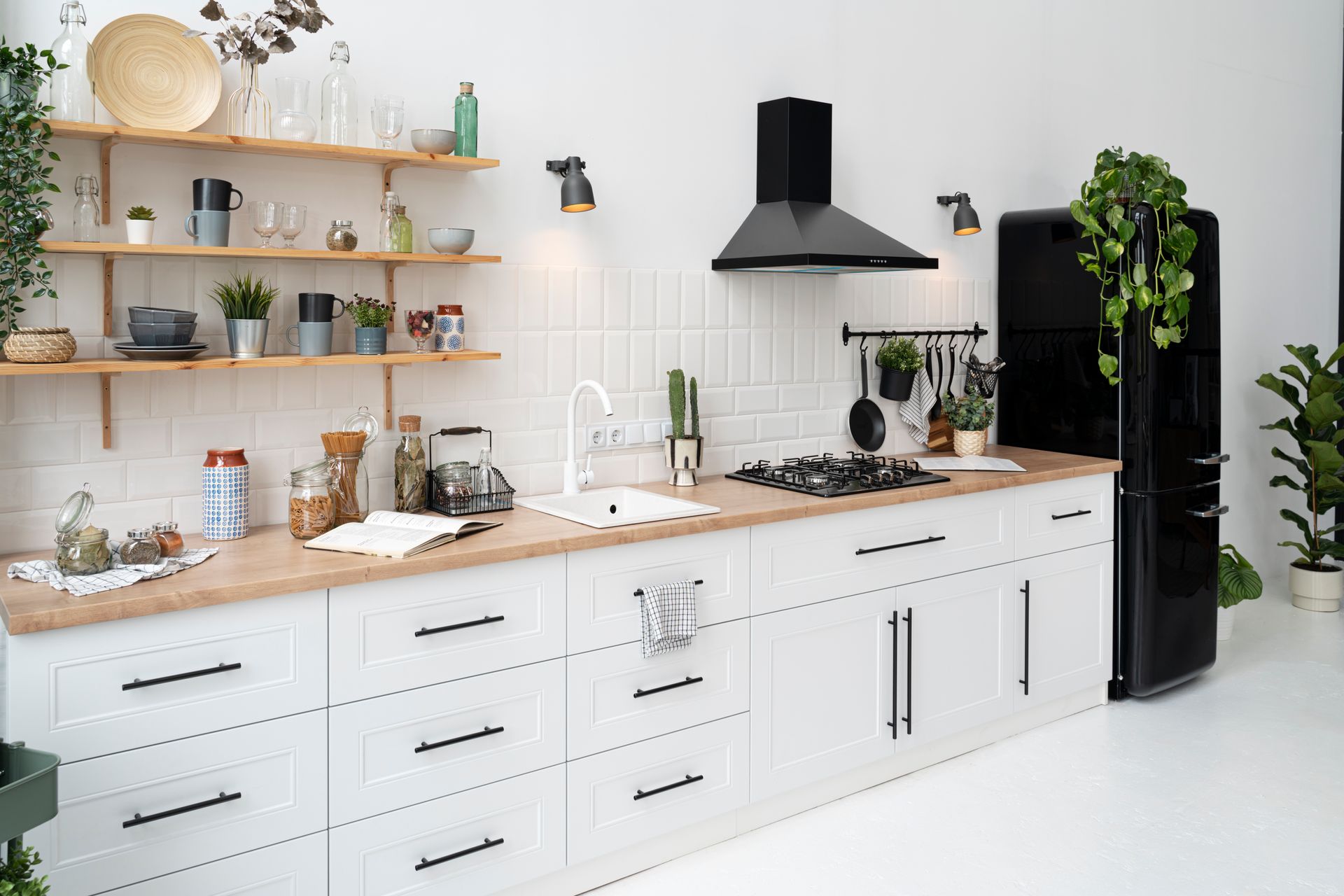 a kitchen with white cabinets and a black refrigerator .