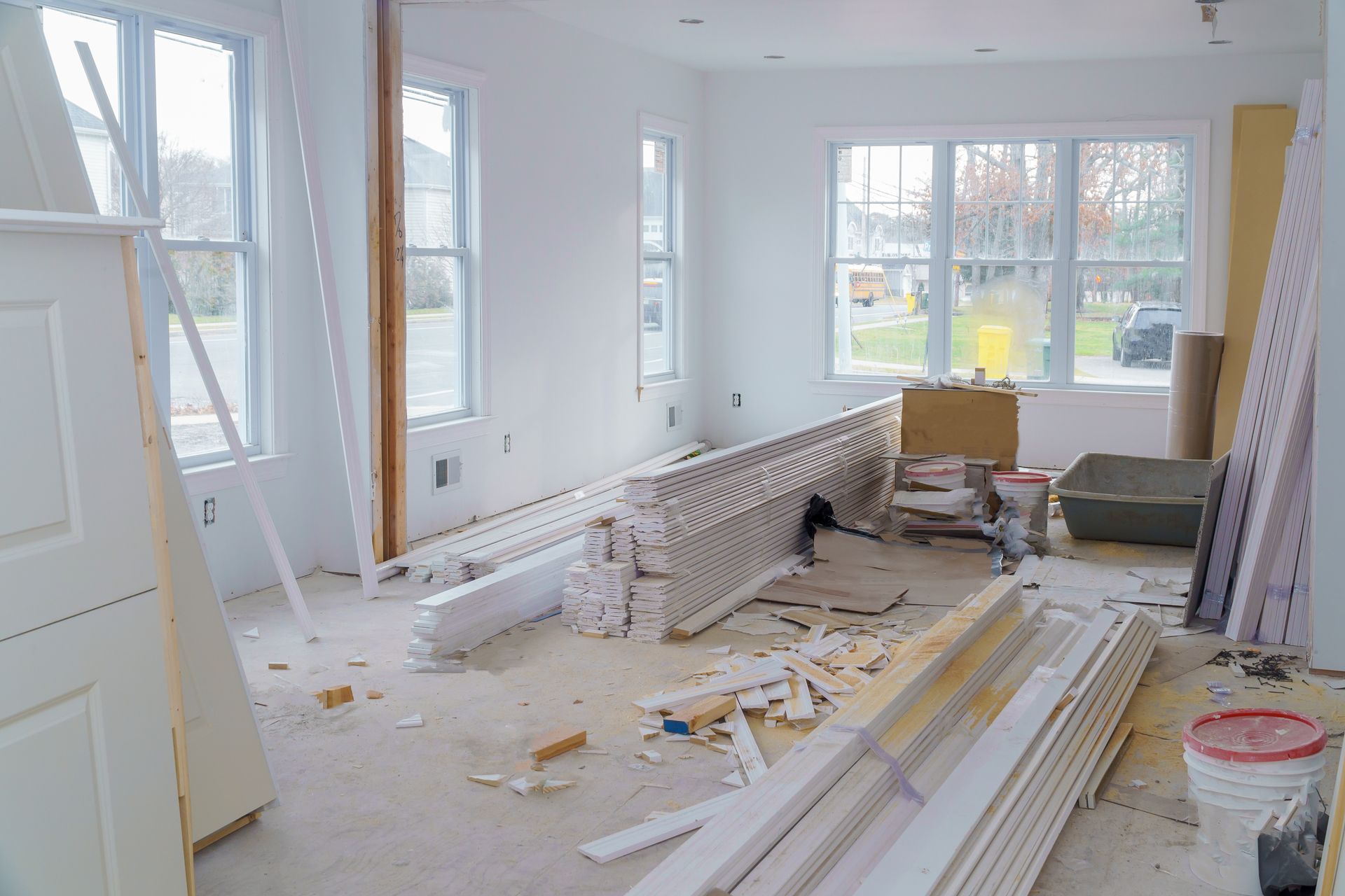 a living room in a house under construction with a lot of wood laying on the floor .