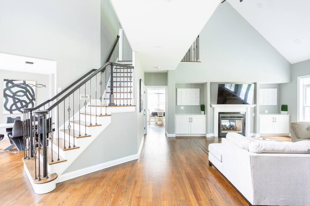 A living room with hardwood floors and stairs leading up to the second floor.