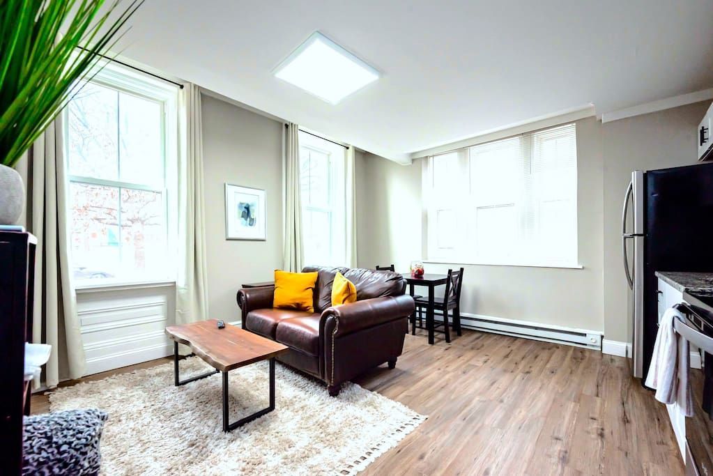 A living room with a couch , table , and refrigerator.