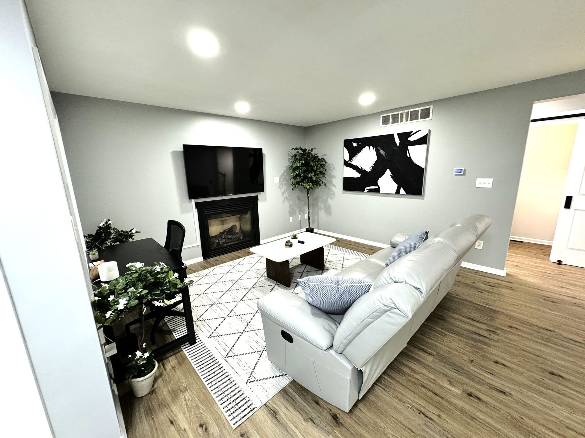 A living room with a couch , fireplace and television.