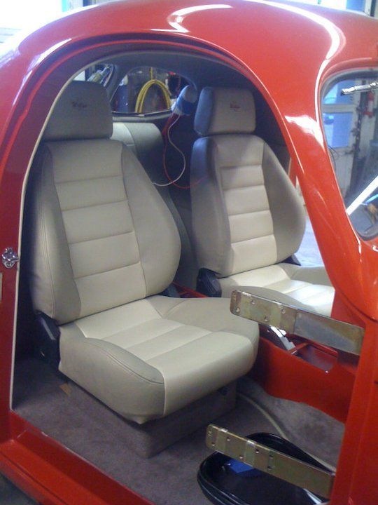a red car with white seats and a steering wheel