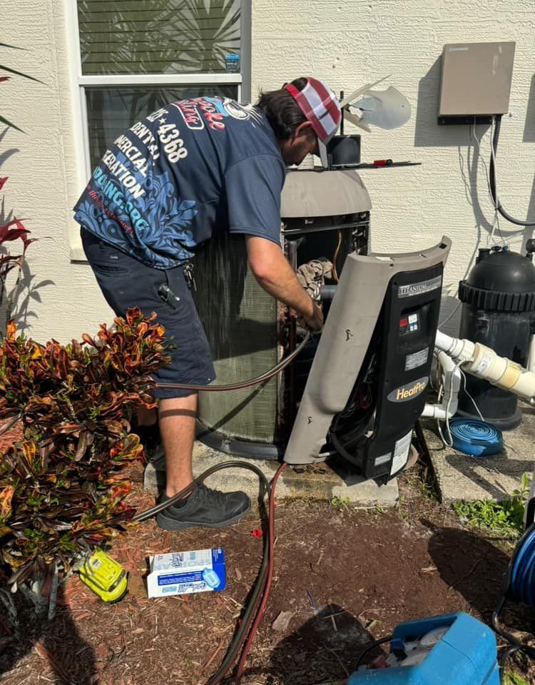 A man is working on an air conditioner outside of a house.