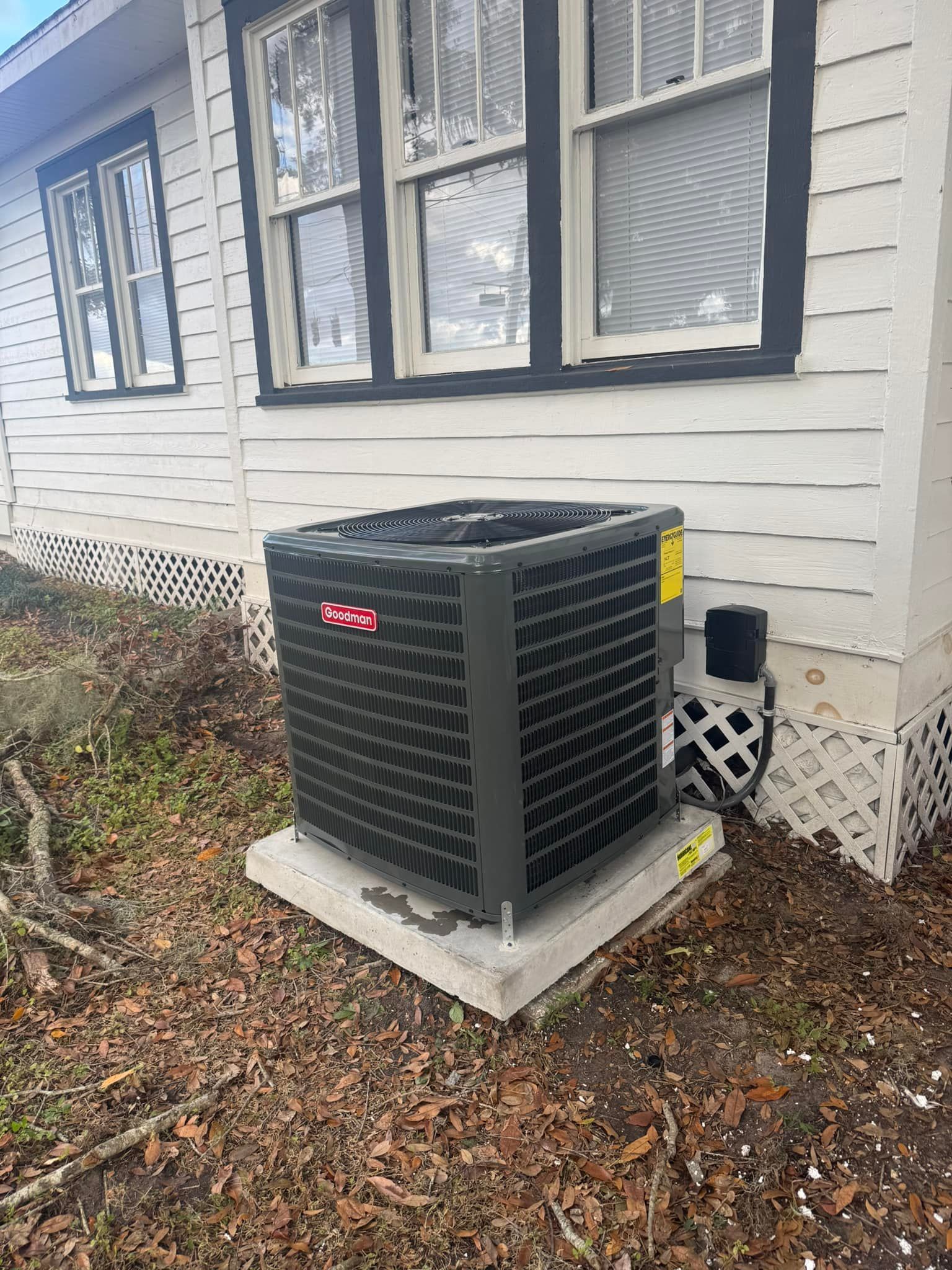 A large air conditioner is sitting on the side of a house.