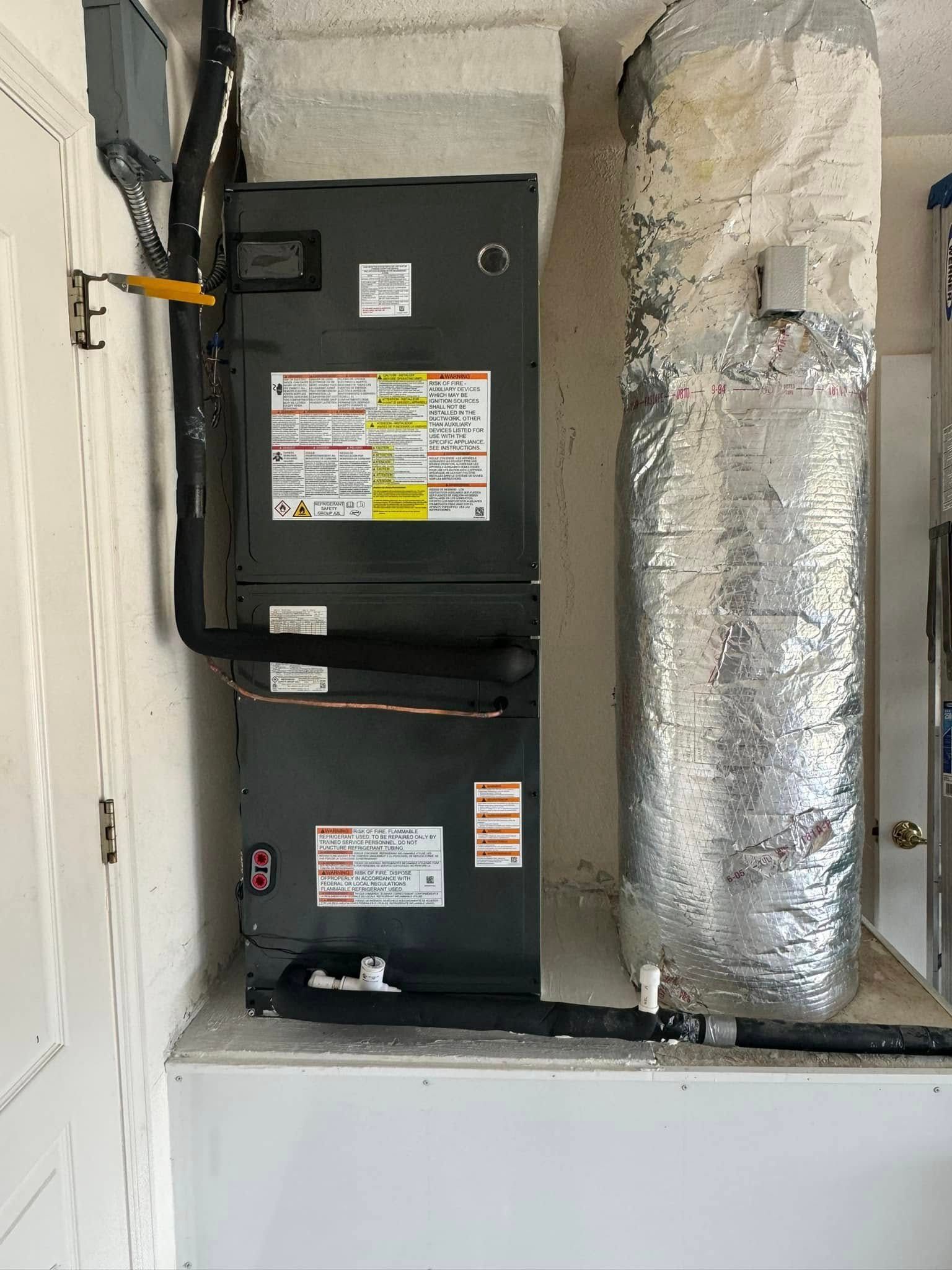 Two air conditioners are stacked on top of each other in a room.