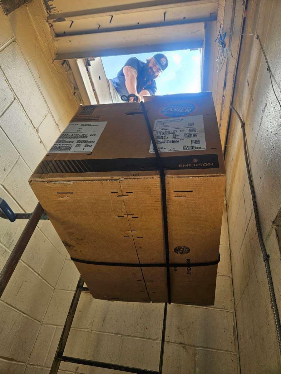 A man is looking through a window at a large cardboard box