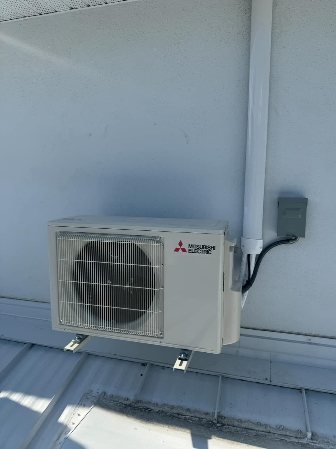 A mitsubishi air conditioner is mounted on the side of a building.