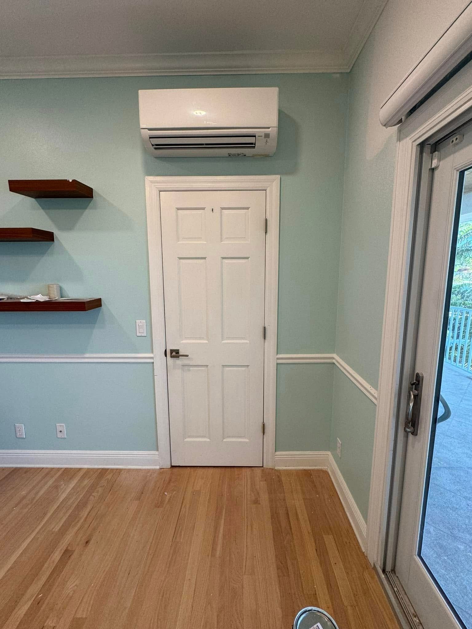 A room with a door , shelves , and air conditioner.