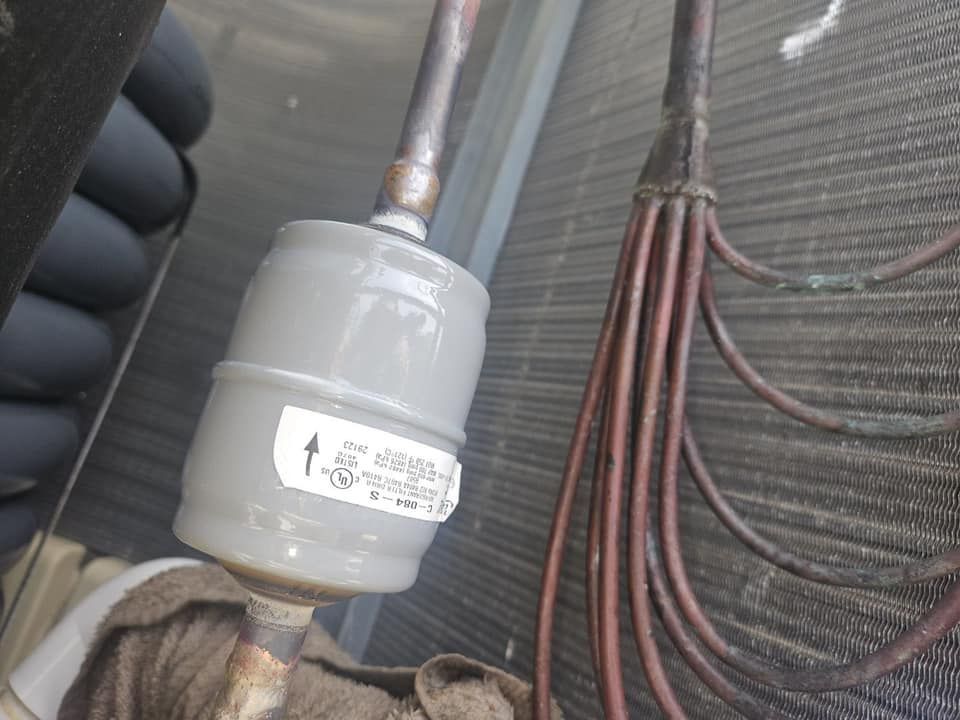 A close up of a copper pipe with a filter attached to it.