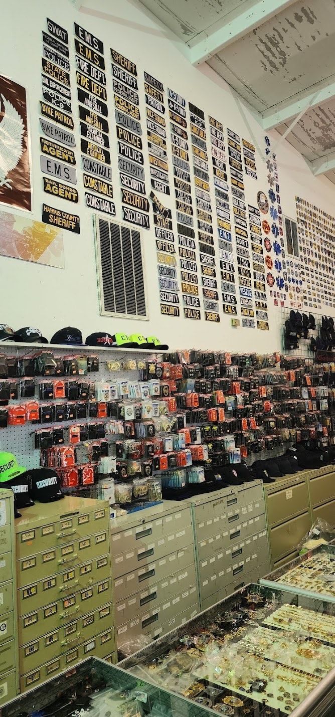 Interior of a store displaying many vintage license plates on the wall above shelves of small packaged items.
