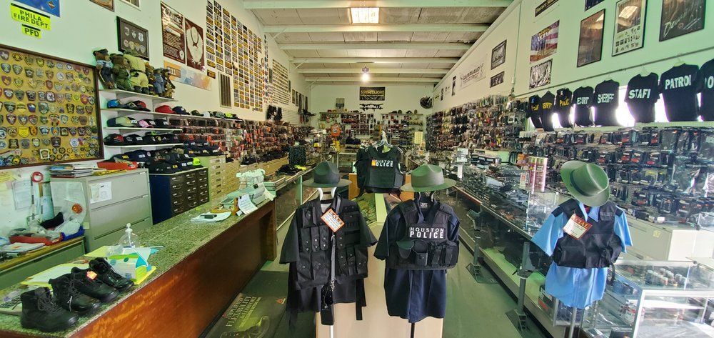 An interior view of a surplus or military gear shop featuring displays of hats, clothing, and tactical accessories.