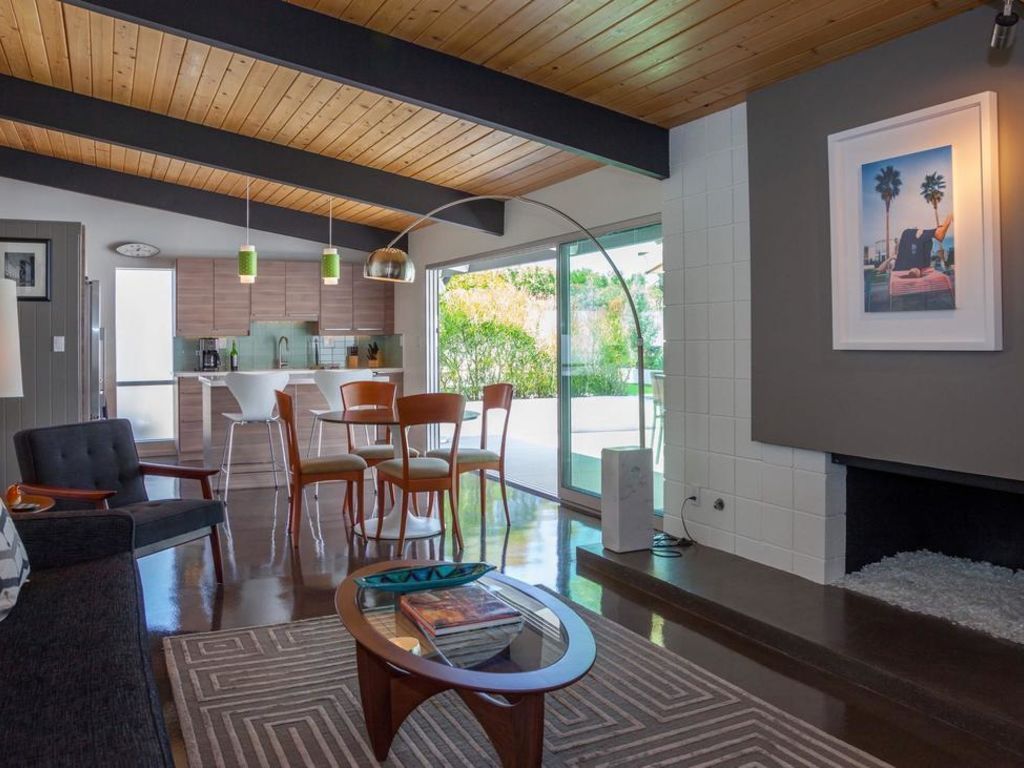 A living room with a couch , chairs , coffee table and fireplace.