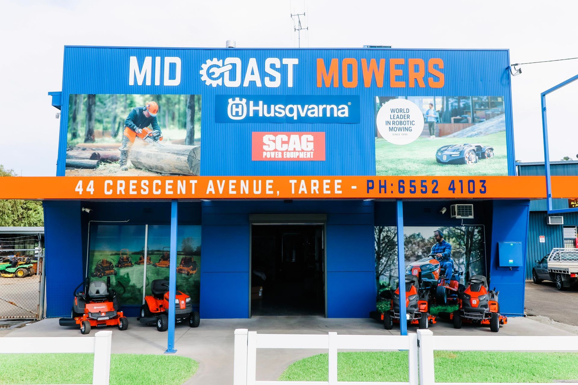 A Blue Building With A Sign That Says Mid Coast Mower — Mid Coast Mowers In Taree, NSW